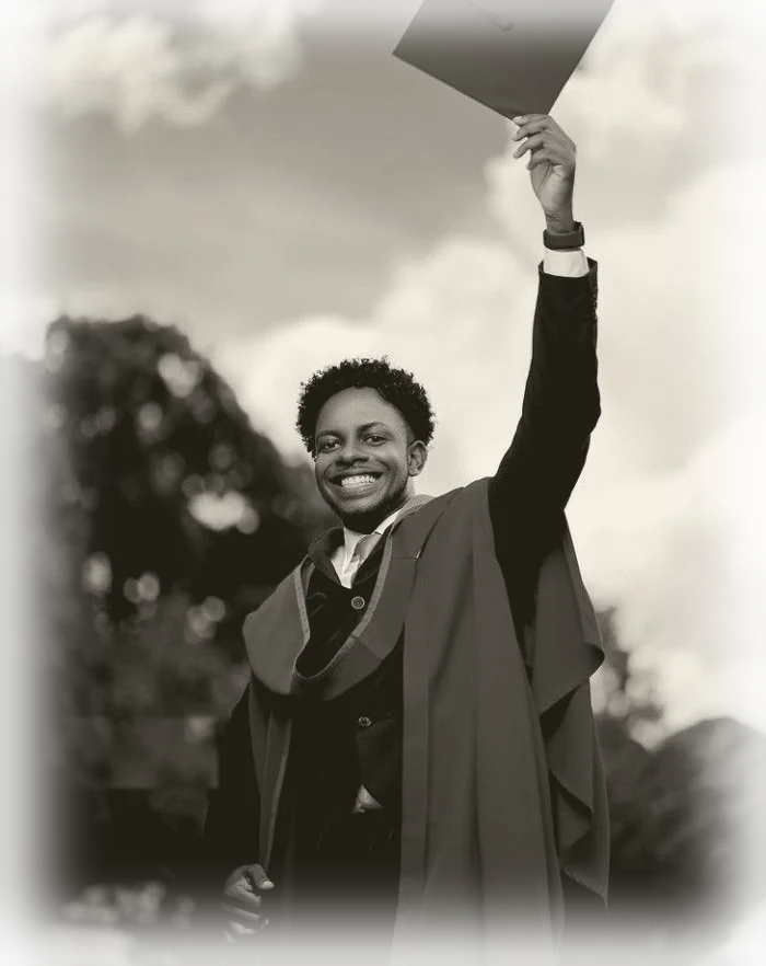 Yousef celebrating his graduation, cap raised